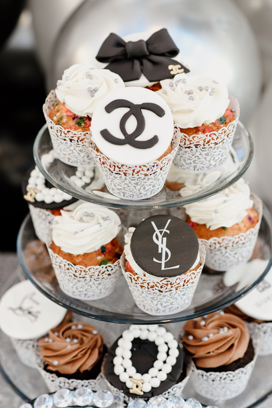 Cupcakes brancos em bandeja de vidro em mesa de doces minimalista