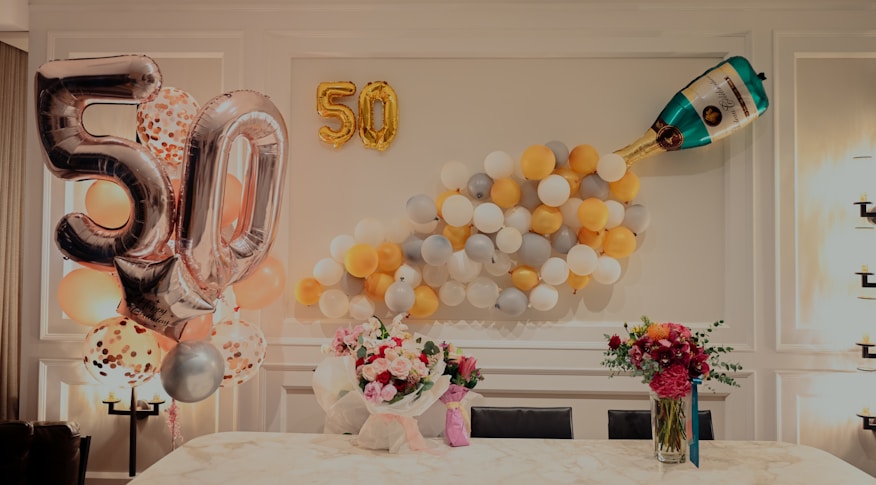 Decoração de festa infantil em casa com balões amarelos e brancos na mesa