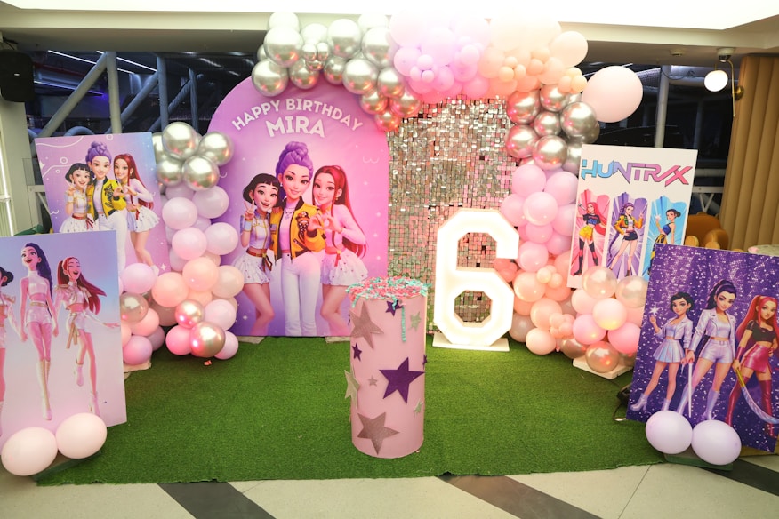 Decoração de festa infantil com balões coloridos e personagens na parede