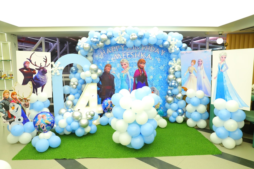 Decoração de festa infantil tema Frozen com balões azuis e brancos