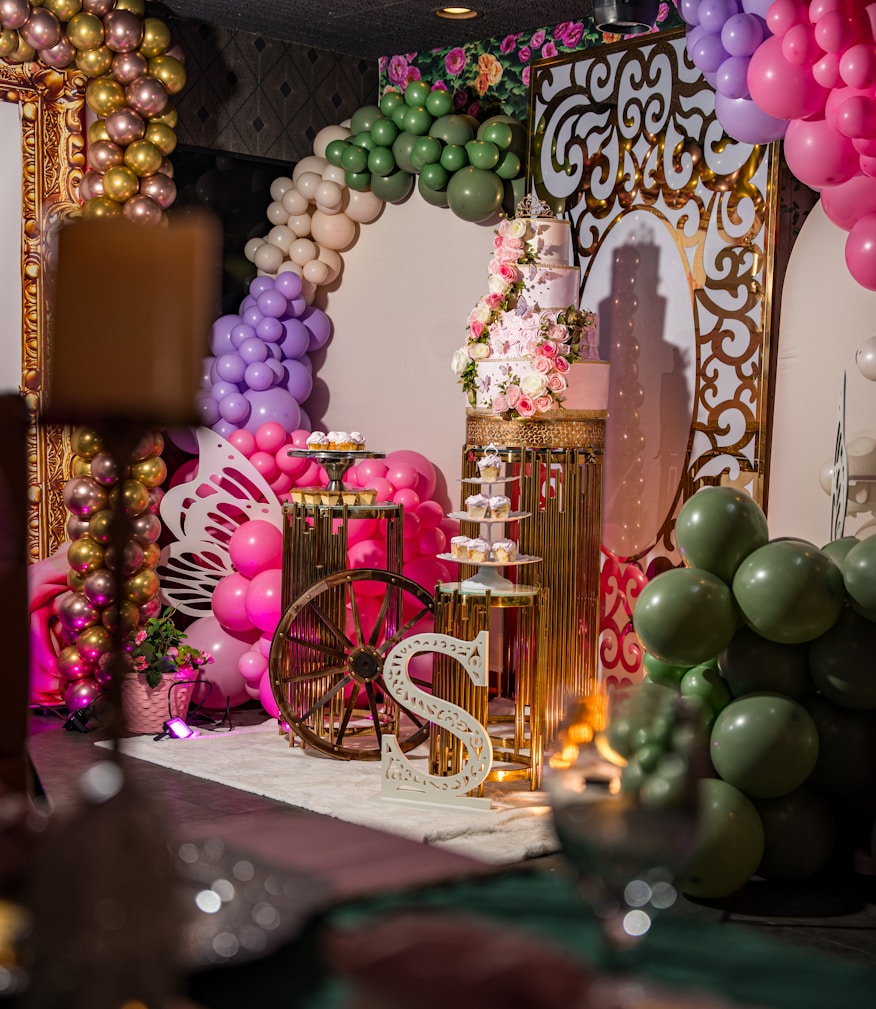 Mesa de festa infantil decorada com baloes coloridos e bolo de aniversario