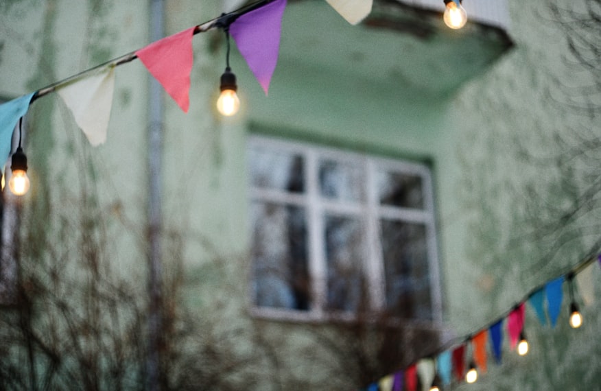 Bandeirinhas coloridas e luzes de festa decorando ambiente ao ar livre