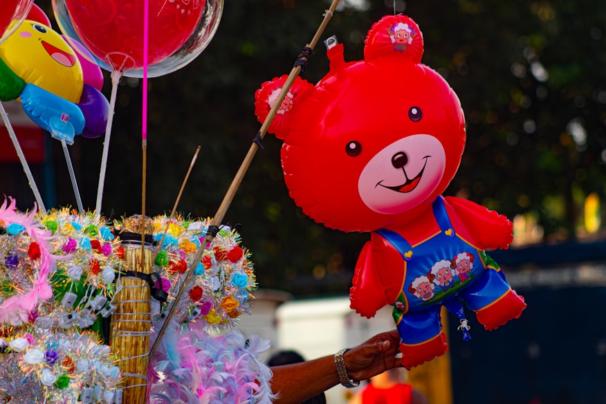 Balão de urso de pelúcia vermelho com outros balões coloridos para festa